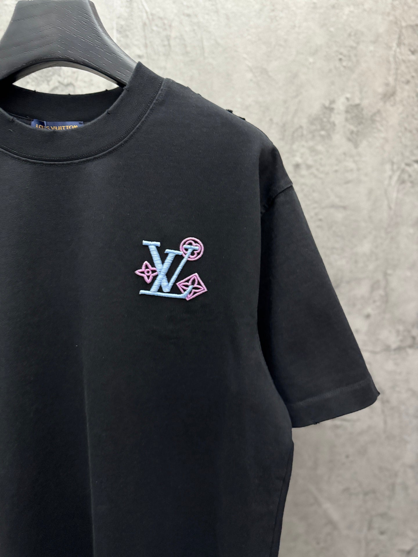 Black T-shirt with LV-style multicolor emblem on left chest