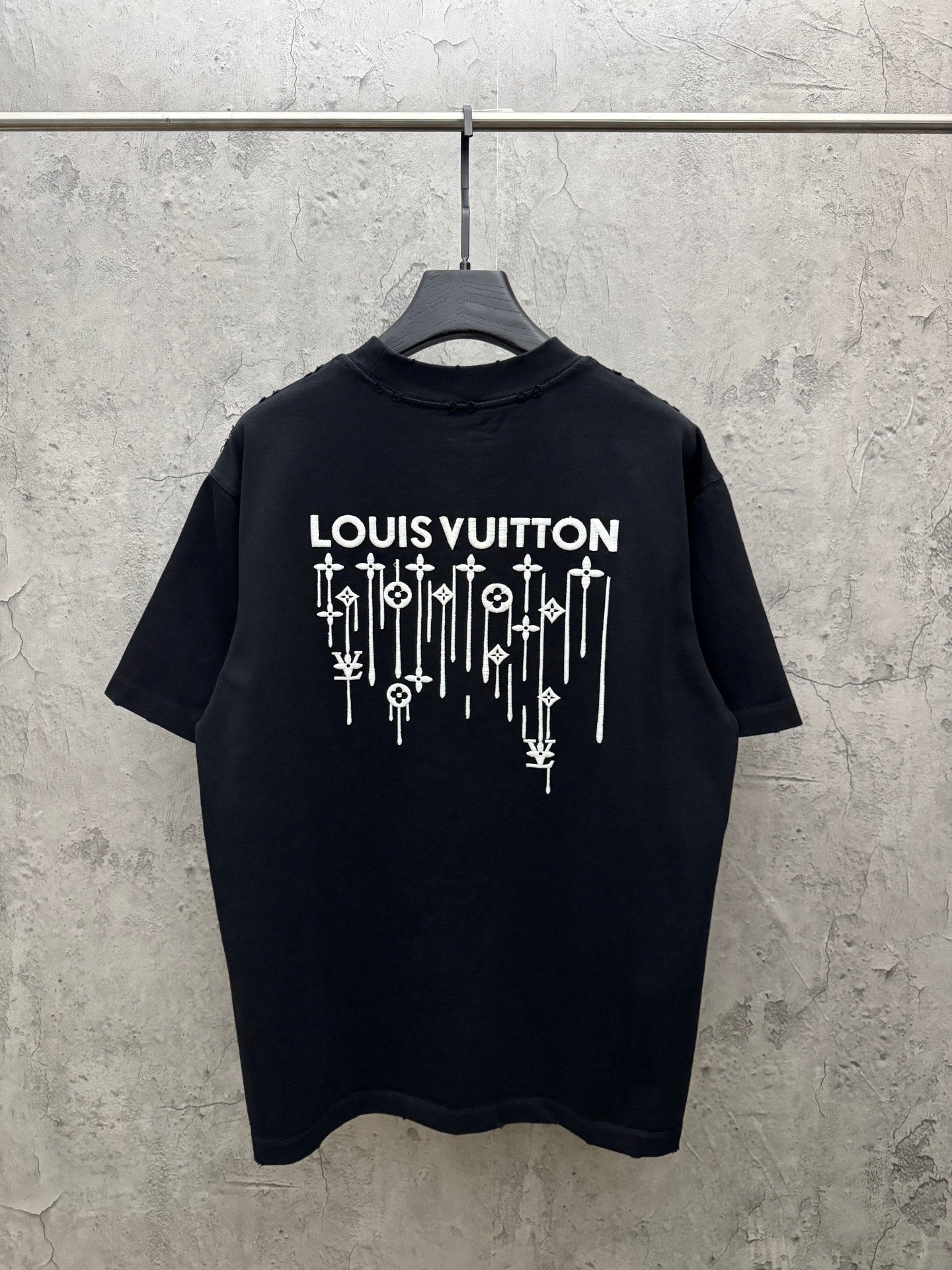 Black T-shirt with LOUIS VUITTON text and multicolor drip graphic on back