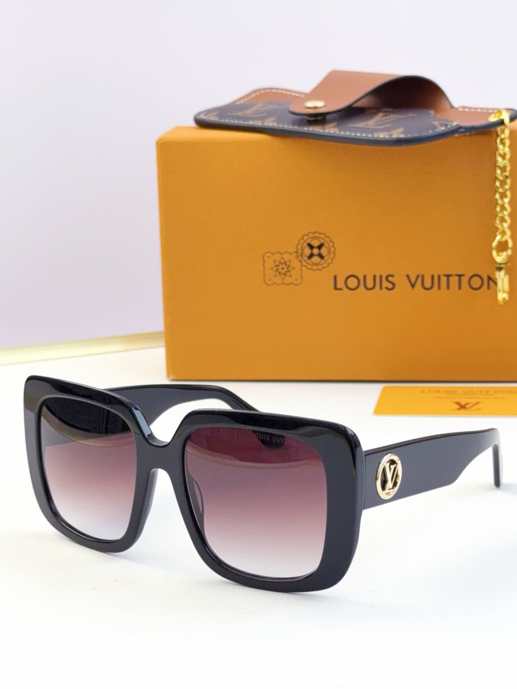 Louis Vuitton sunglasses, purple-tinted lenses, black and navy frame with gold logo