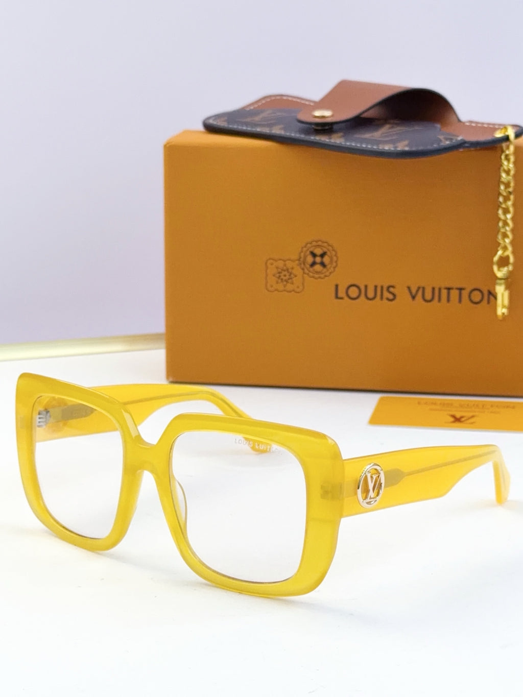 Louis Vuitton sunglasses, yellow frame, clear lenses, gold logo metal accents