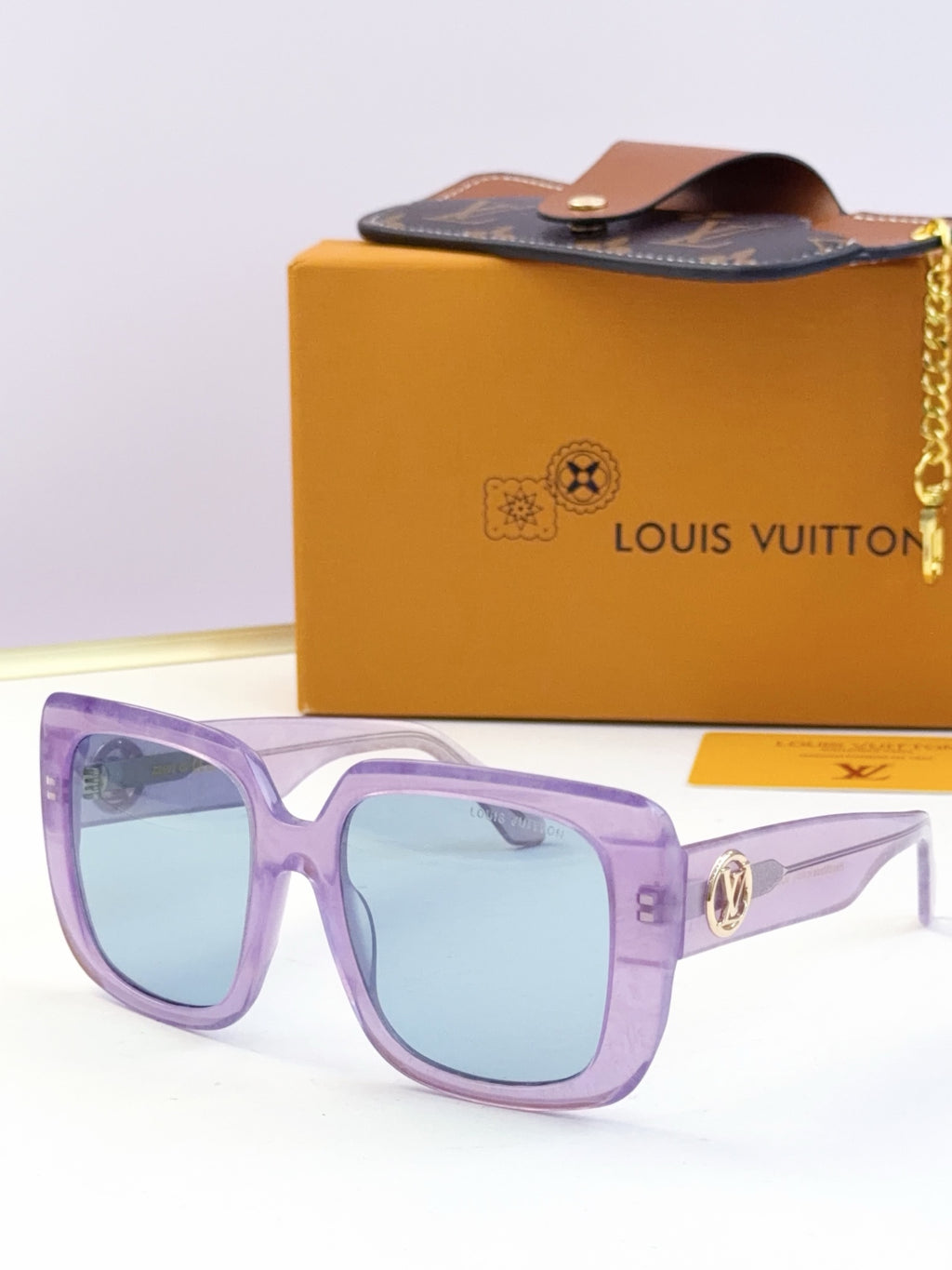 Louis Vuitton sunglasses, purple frame, light blue lenses, gold logo metal detail