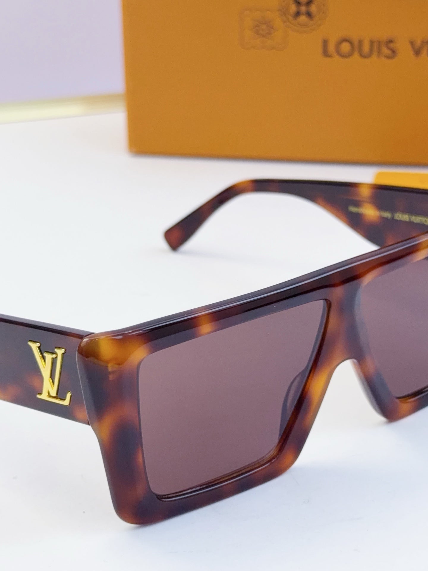 Louis Vuitton tortoiseshell square sunglasses with tinted lenses and gold LV logo.