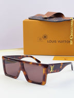Louis Vuitton tortoiseshell sunglasses with tinted lenses and gold LV logo on temple.