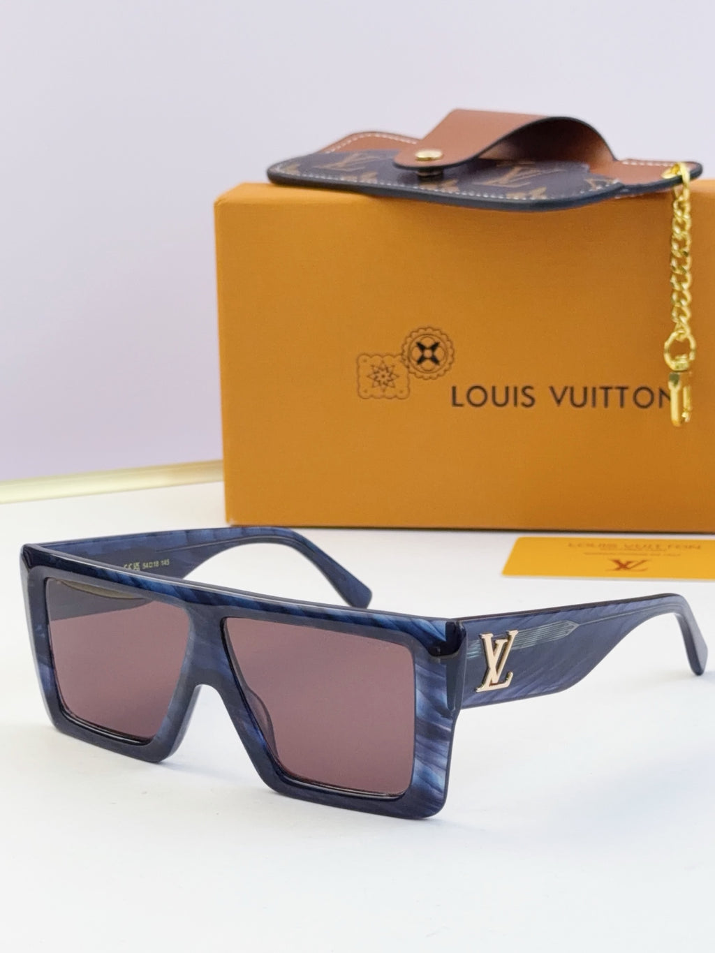 Louis Vuitton blue sunglasses with dark lenses and gold LV emblem on temple.