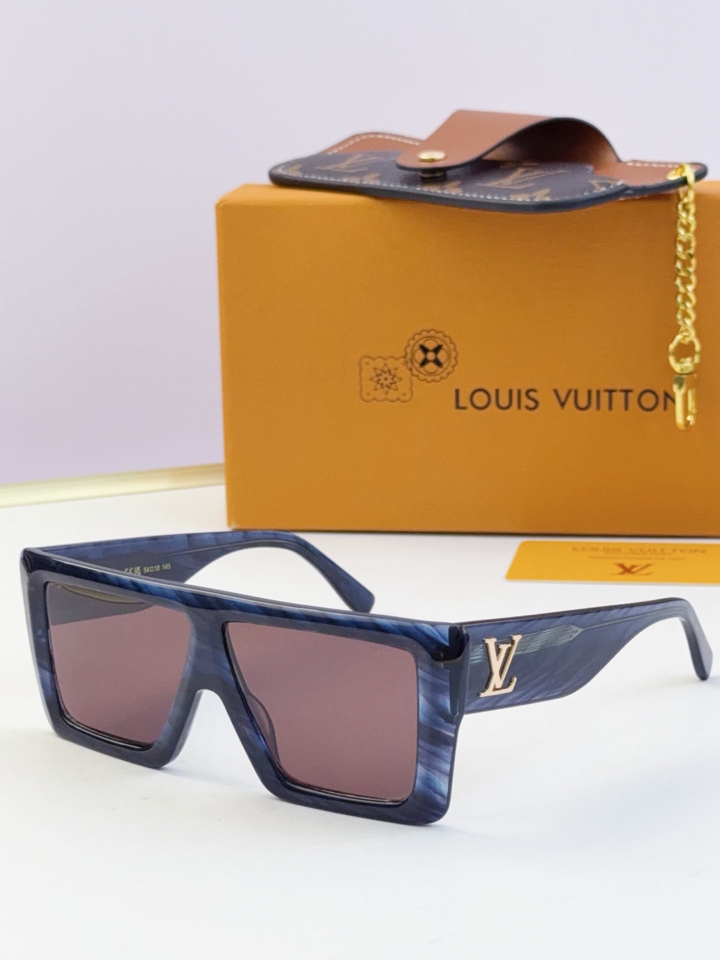 Louis Vuitton blue sunglasses with dark lenses and gold LV emblem on temple.