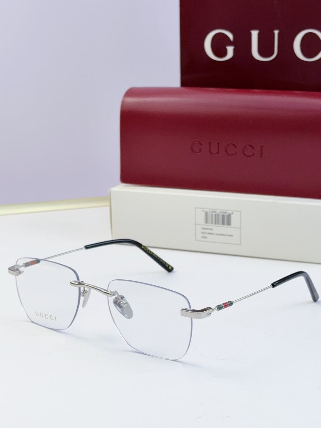 Gucci eyeglasses with clear lenses, metal half-rim frame, black temples and multicolor stripe detail