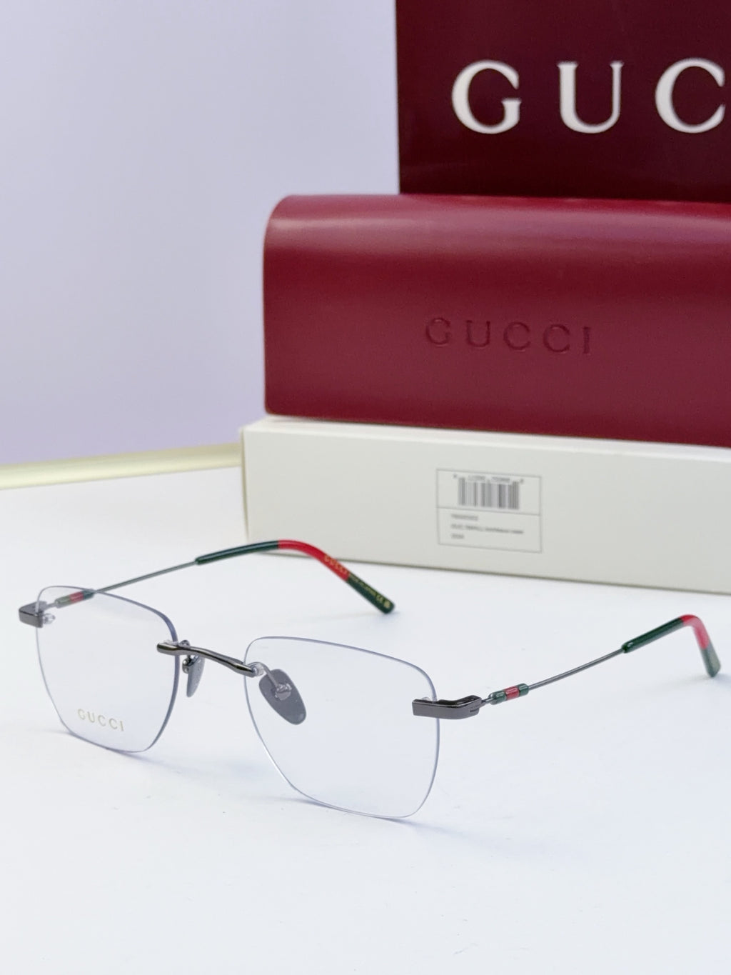 Gucci eyeglasses with clear lenses, thin metal frame, black temples with multicolor stripe detail