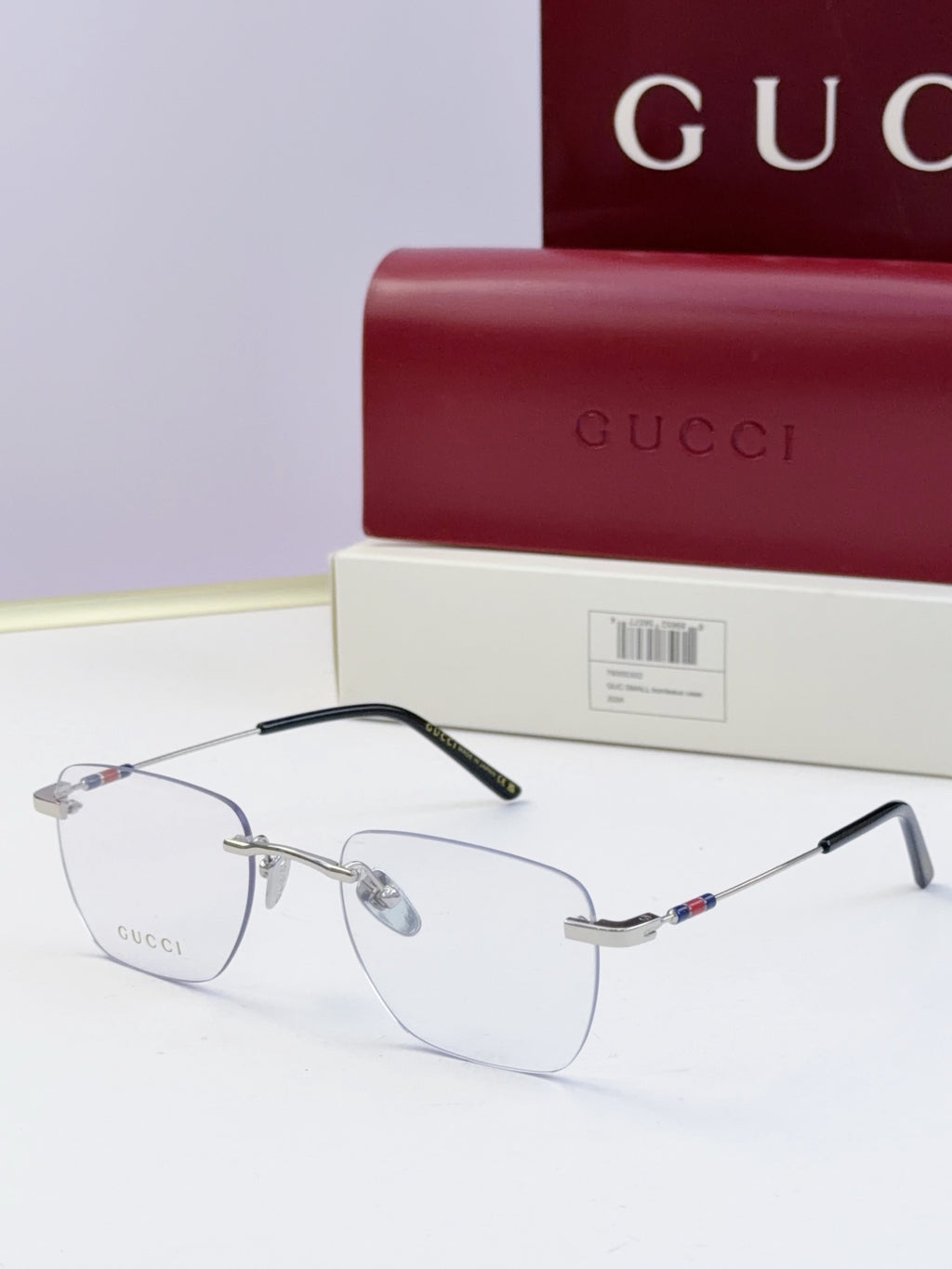 Gucci eyeglasses with clear lenses and metal frame, black temple arms with multicolor stripe accent