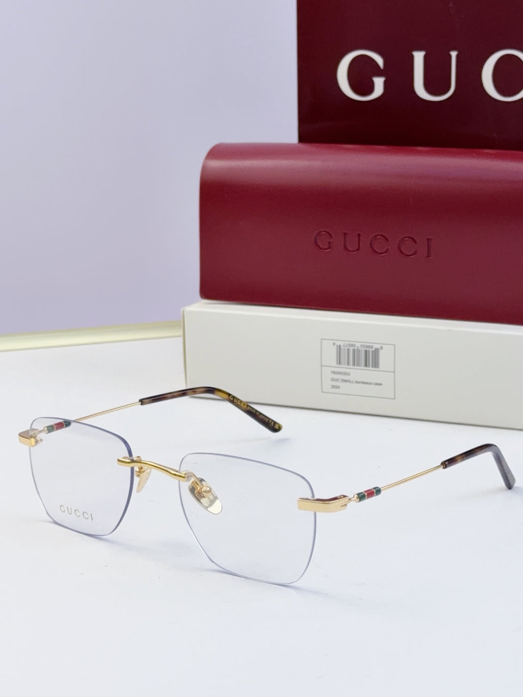 Gucci eyeglasses with clear lenses and metal frame, dark temples with multicolor stripe and gold-tone bridge