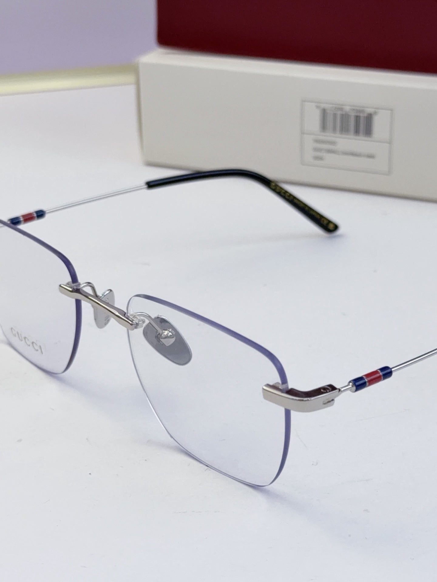 Gucci eyeglasses with clear lenses, thin blue temple arms and multicolor stripe near the hinge