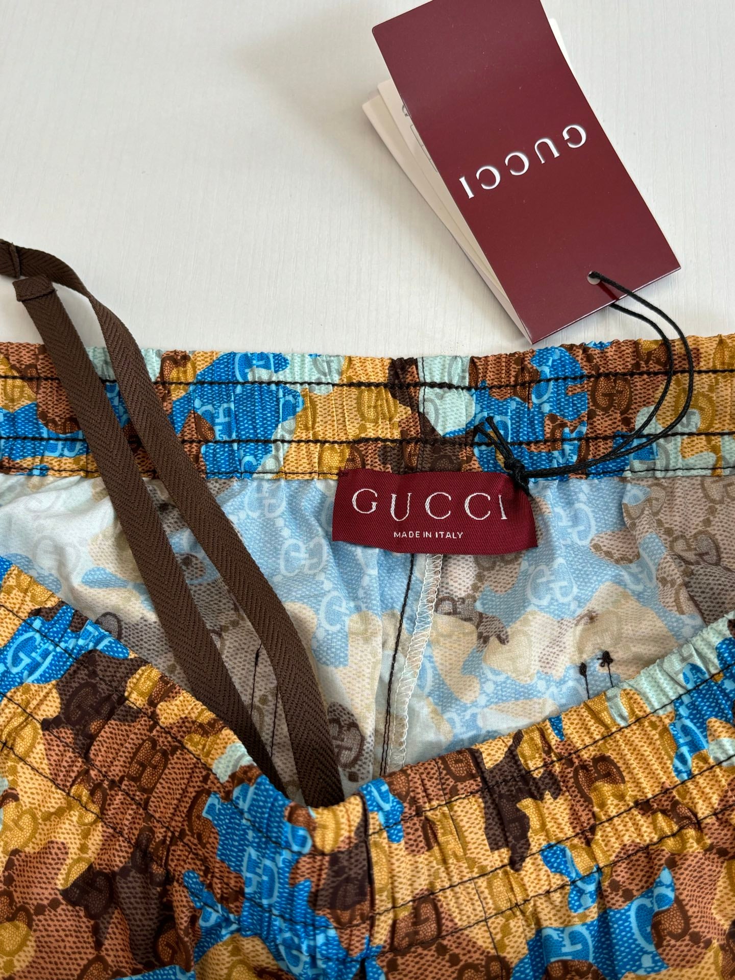 Gucci shorts with red Gucci brand tag on waistband, blue and brown print.