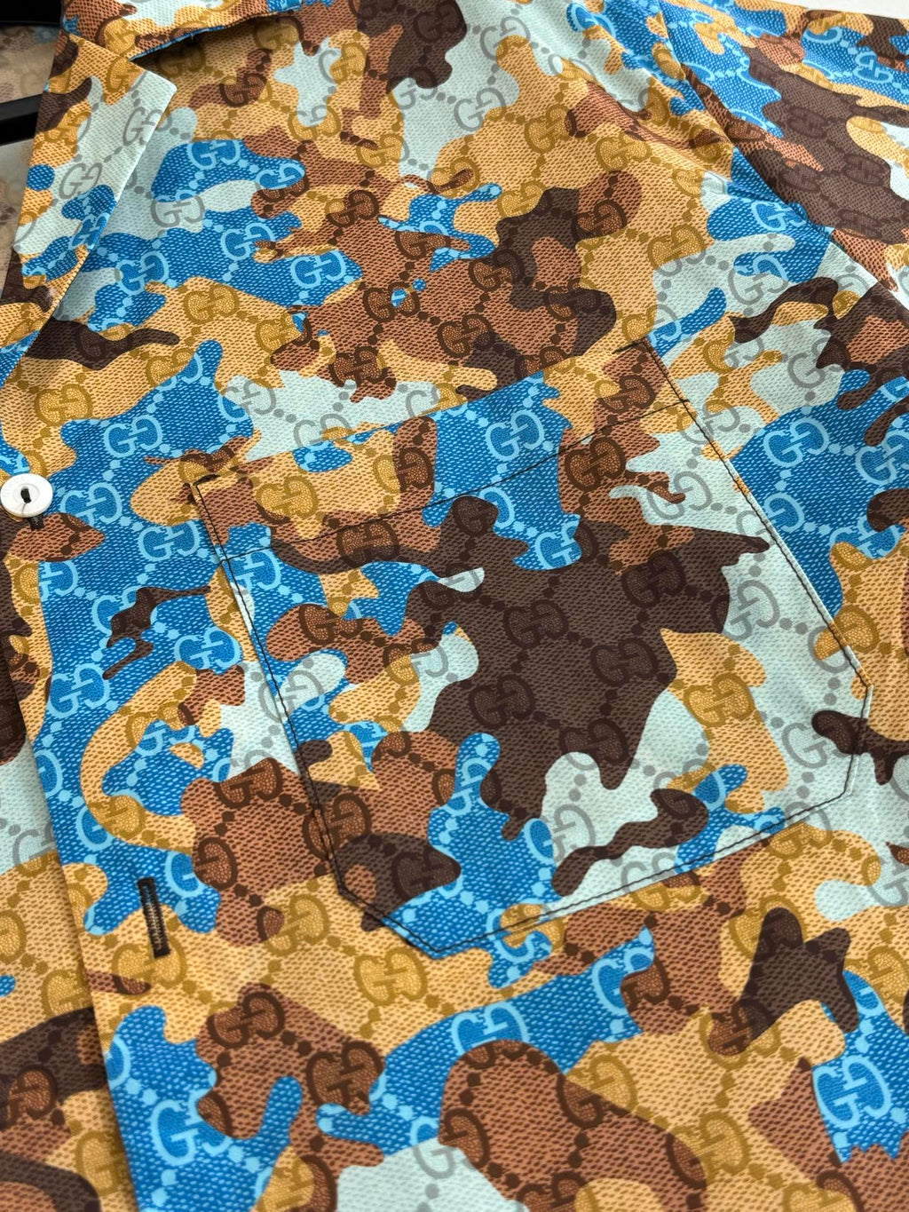 Short-sleeve shirt fabric close-up with blue and brown abstract print