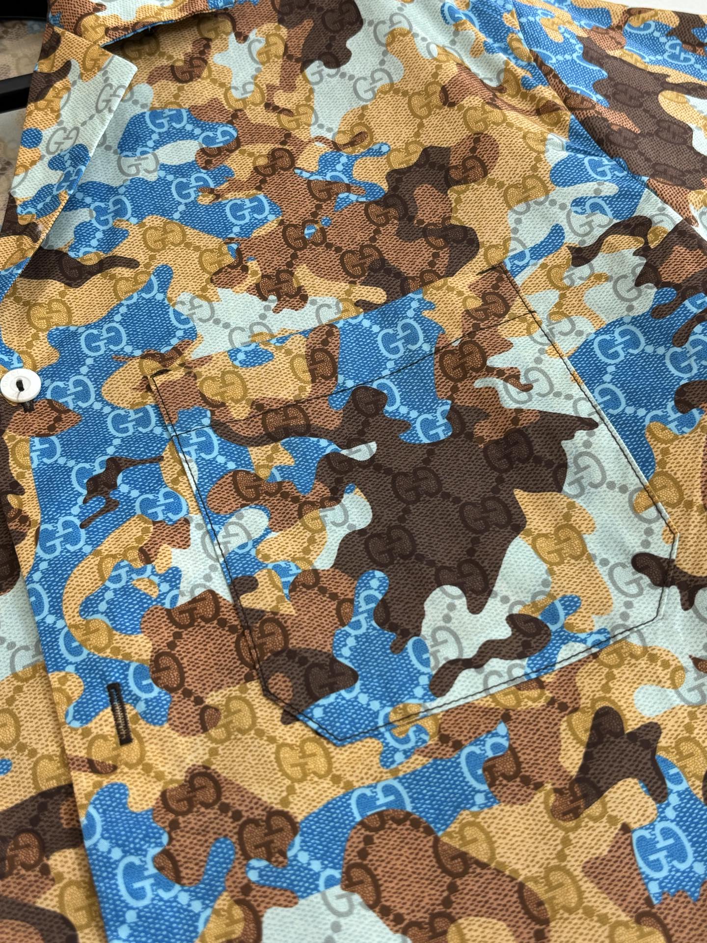 Short-sleeve shirt fabric close-up with blue and brown abstract print