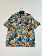 Short-sleeve button-up shirt with pointed collar, blue tan abstract print, front view