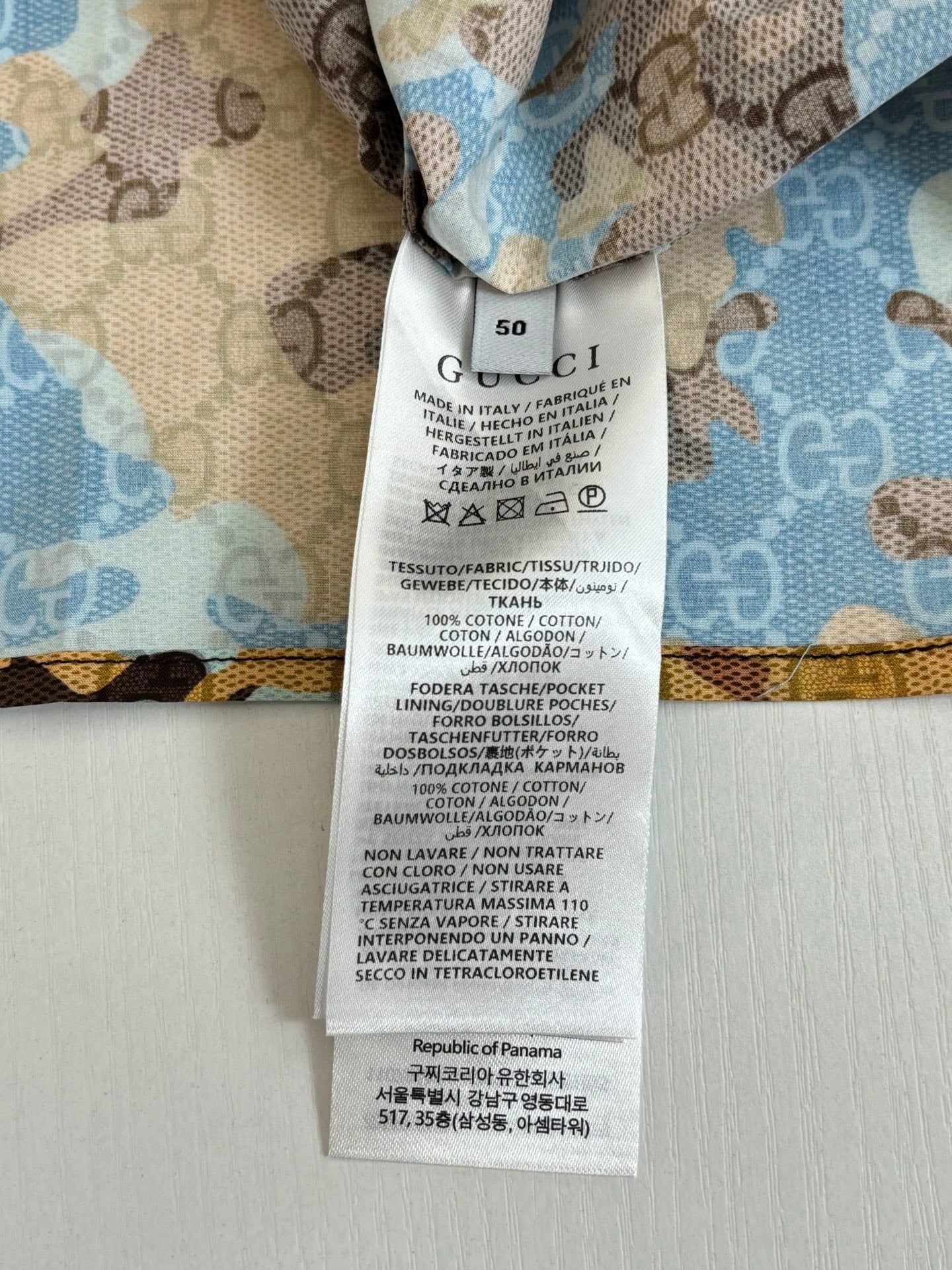 Gucci short with stitched care label on light blue patterned fabric