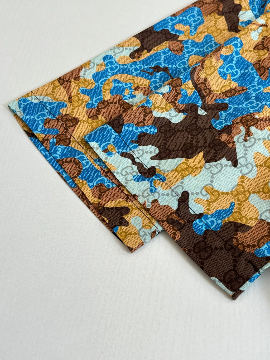 Short-sleeve shirt sleeve cuff detail, blue and brown abstract print
