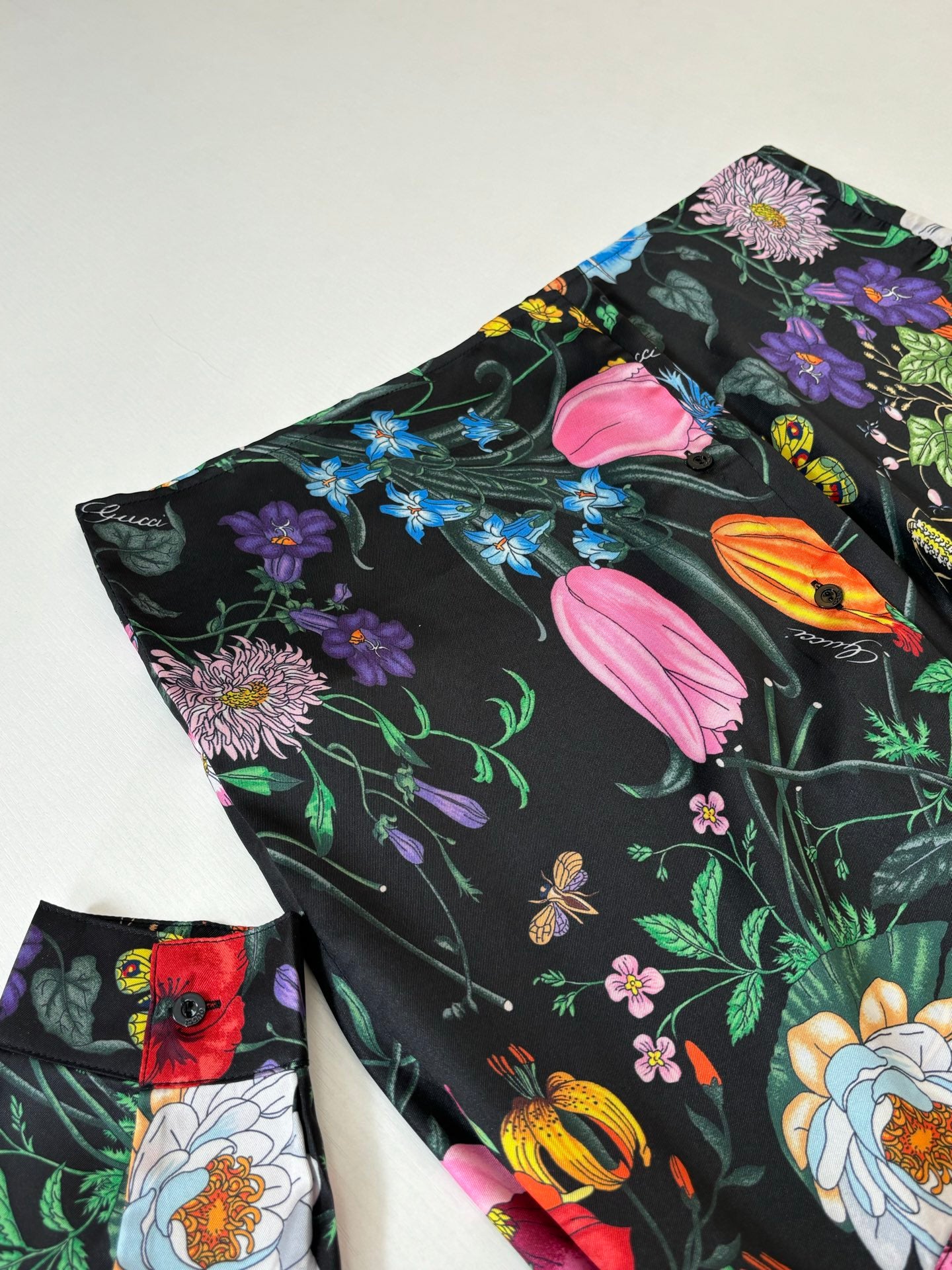 Folded black shirt showing colorful tulip and flower print