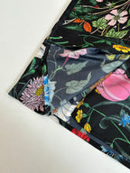 Black shirt sleeve close-up with floral print and dark leaves