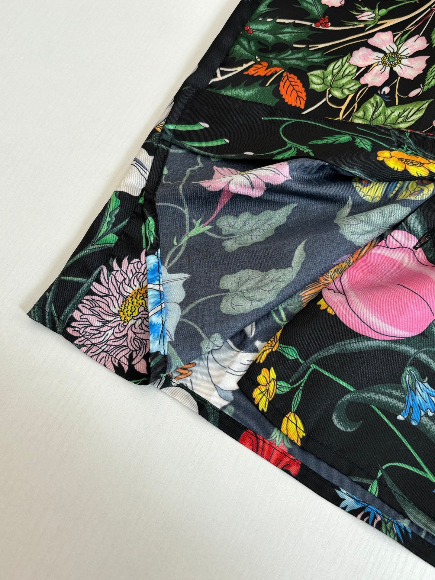 Black shirt sleeve close-up with floral print and dark leaves