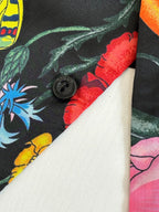 Buttoned cuff detail on dark shirt with colorful botanical print