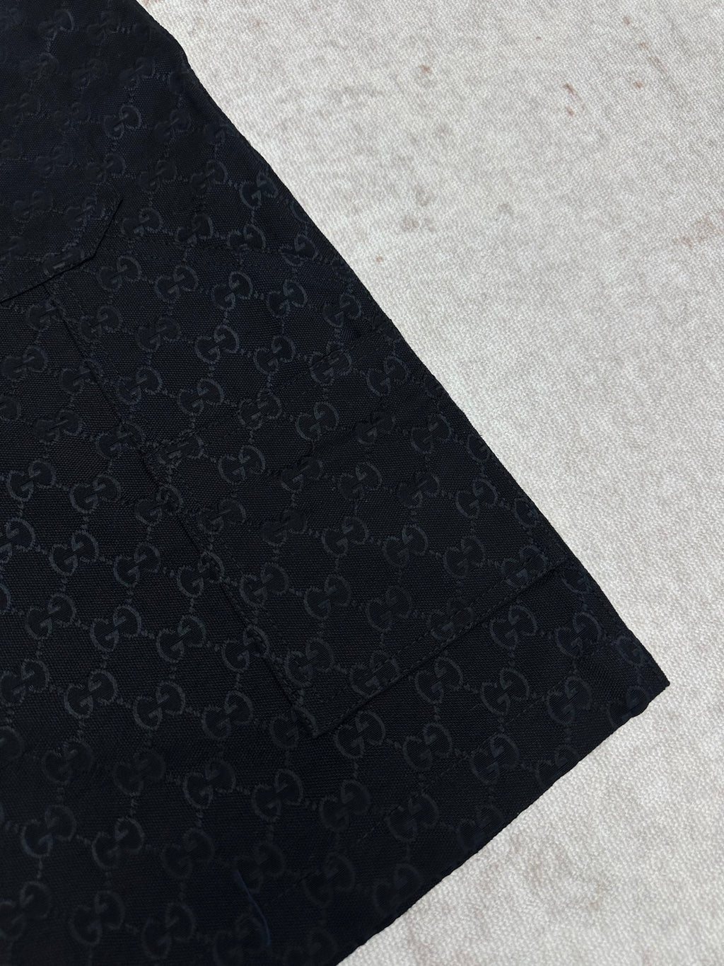 Gucci dark navy shorts with GG-style monogram pattern, side view and tapered hem