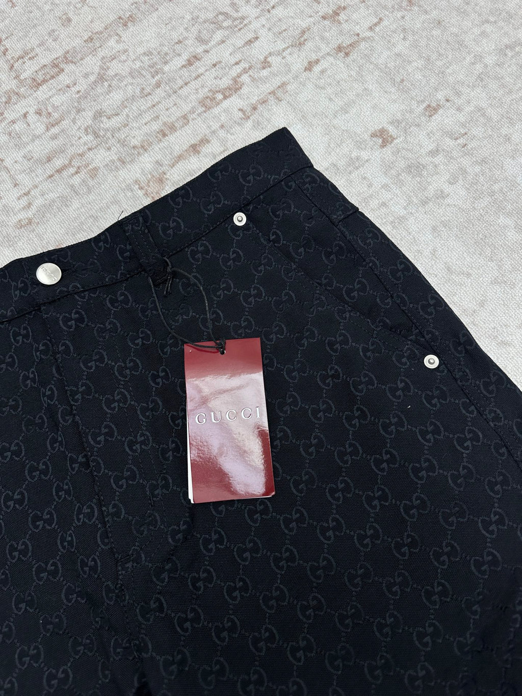 Gucci dark navy shorts with GG-style monogram pattern, snap buttons on waistband