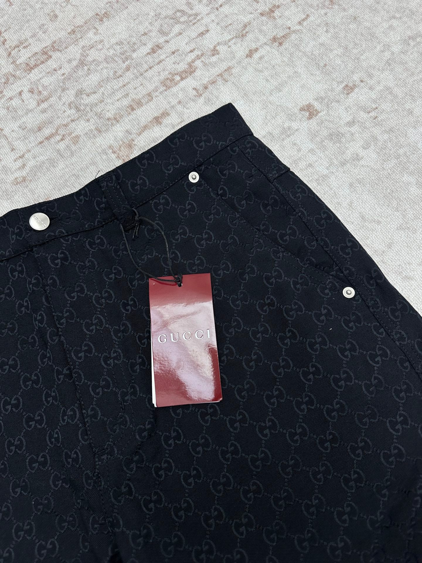 Gucci dark navy shorts with GG-style monogram pattern, snap buttons on waistband