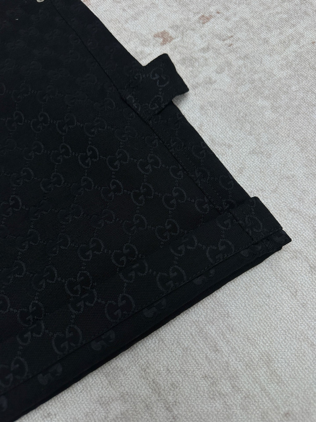 Gucci dark navy shorts with GG-style monogram pattern, angled front seam detail