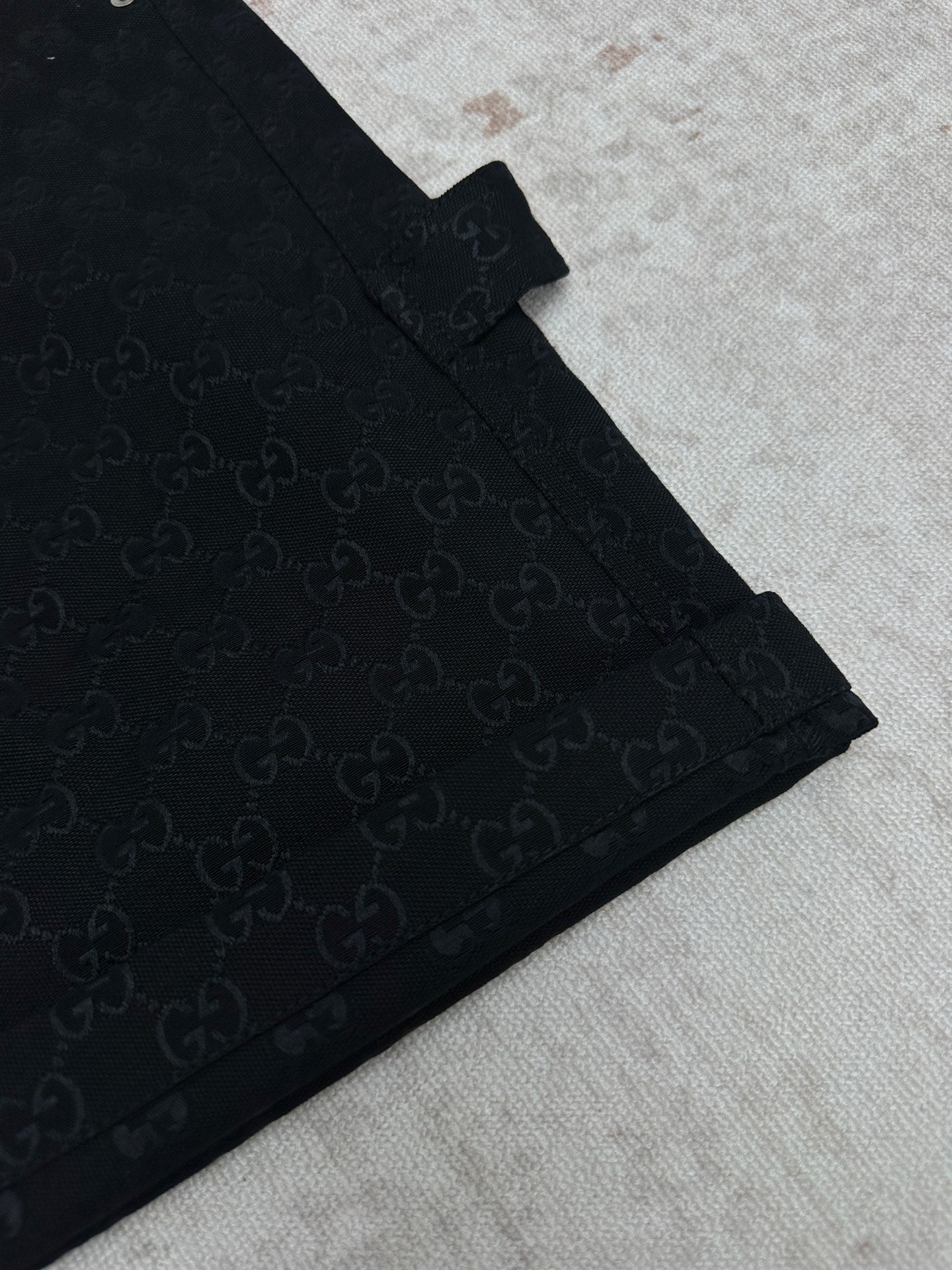 Gucci dark navy shorts with GG-style monogram pattern, angled front seam detail