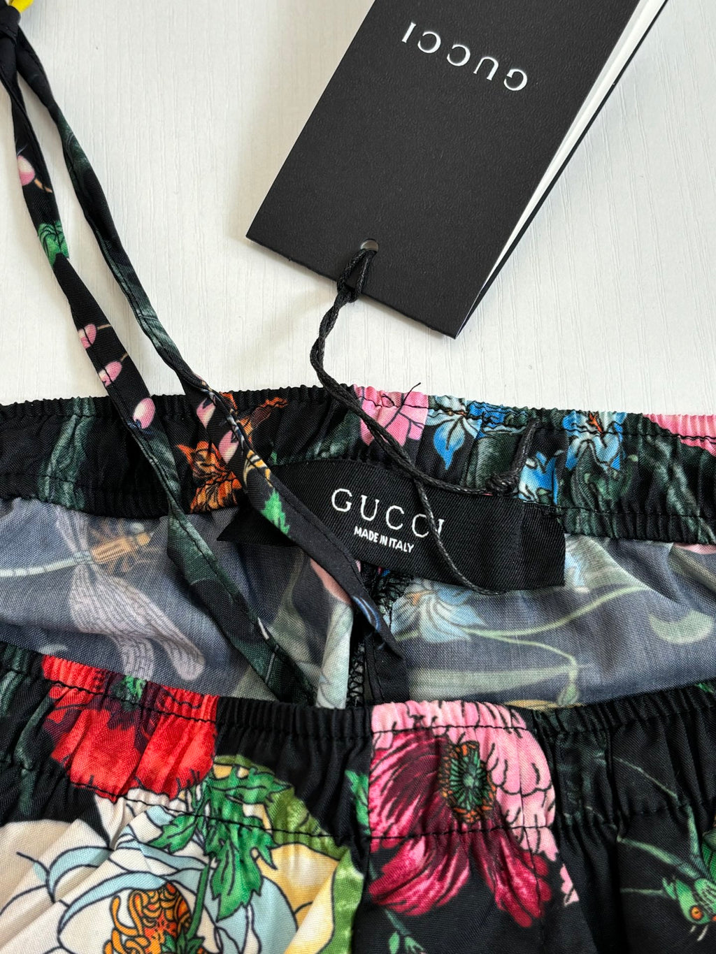 Gucci logo waistband on floral shorts, elastic with black and gray pattern