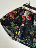 Gucci floral shorts fabric close-up showing black base and colorful blooms