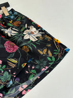 Gucci floral print shorts close-up with large flowers and foliage on black