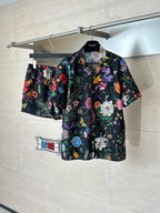Black Gucci short-sleeve shirt on hanger with colorful flower and leaf print