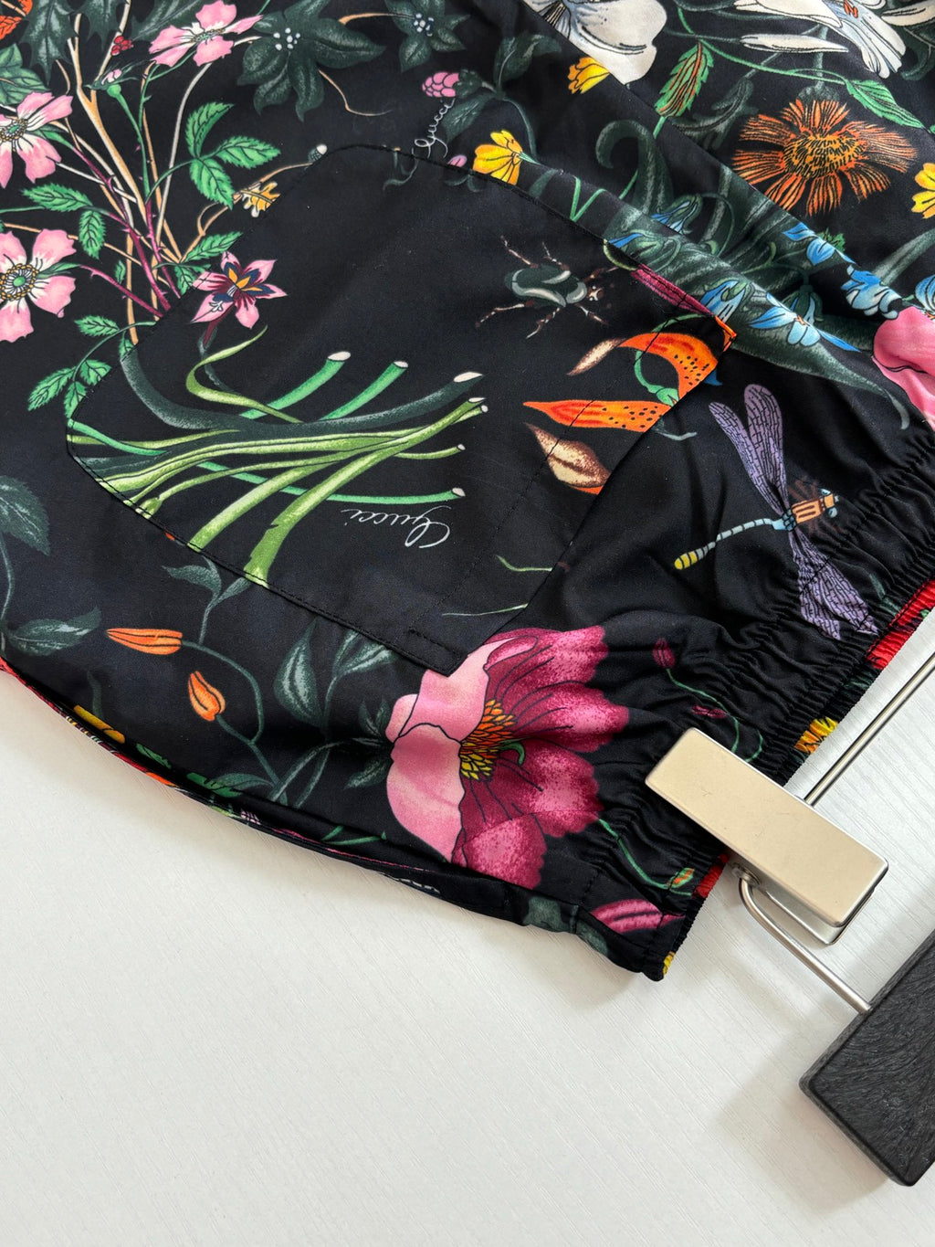 Gucci floral shorts close-up with multicolor bird and flowers on black