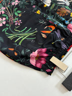 Gucci floral shorts close-up with multicolor bird and flowers on black