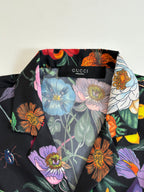Gucci short-sleeve shirt fabric close-up, multicolor floral print on dark base