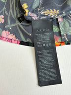 Floral Gucci shorts with black care label and size text