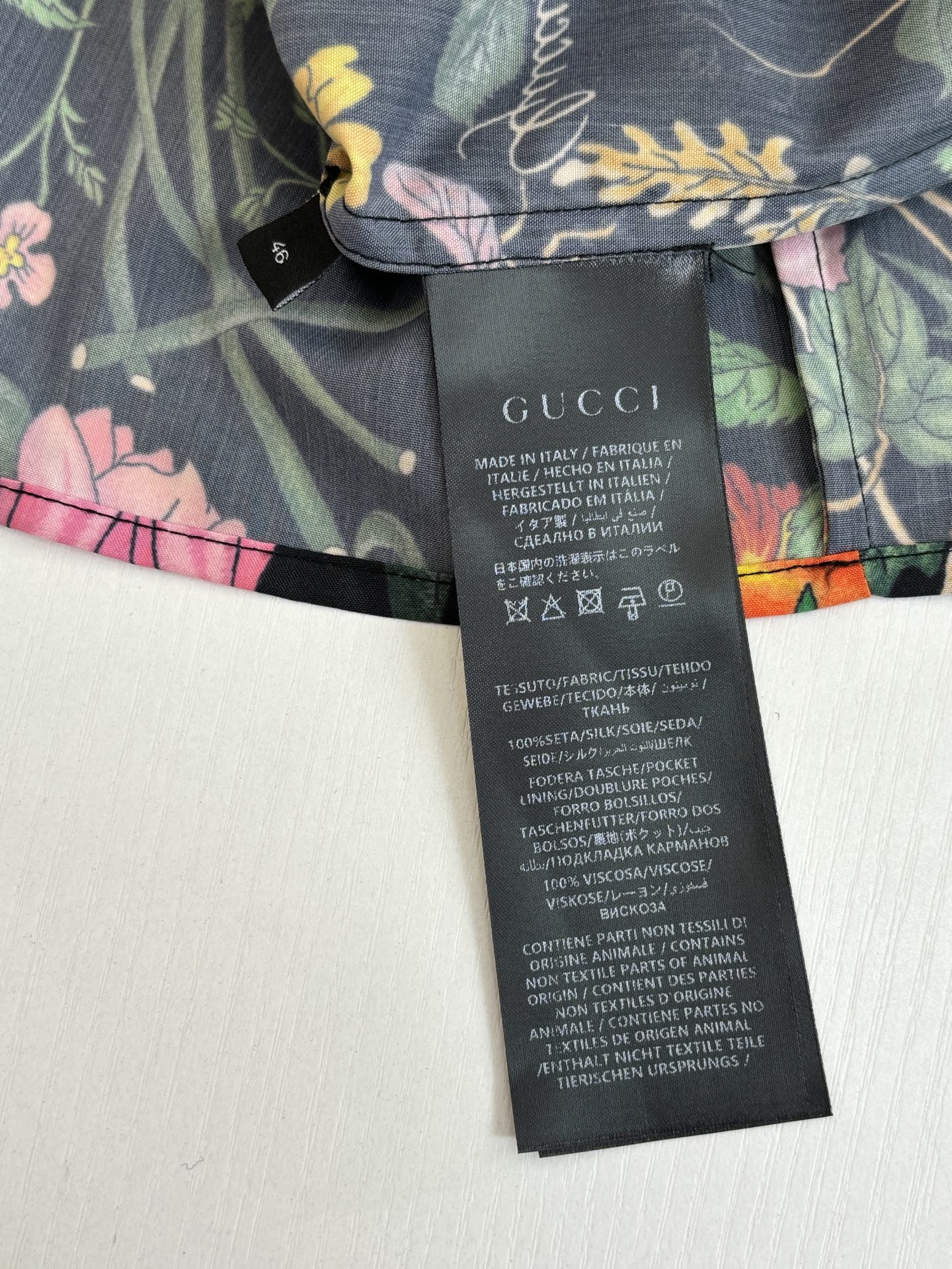 Floral Gucci shorts with black care label and size text