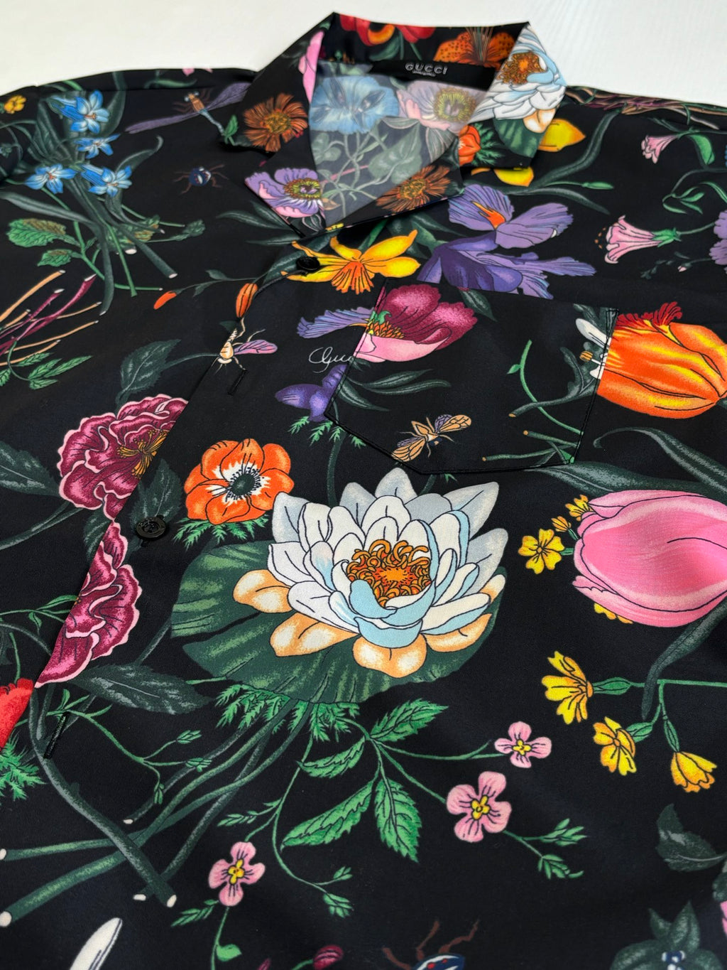 Black Gucci short-sleeve shirt with large floral and butterfly motifs, front close-up