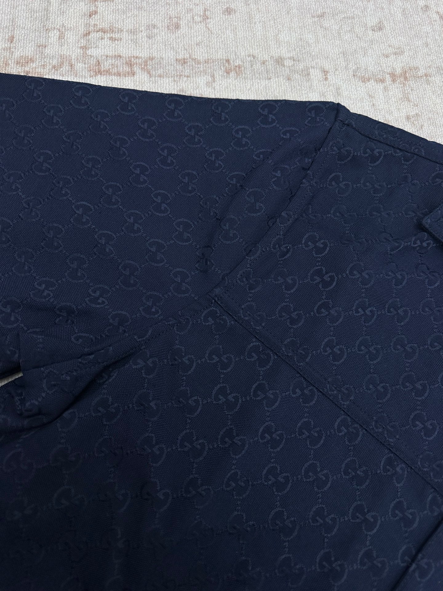 Dark navy short-sleeve shirt fabric with stitched seams and subtle GG pattern