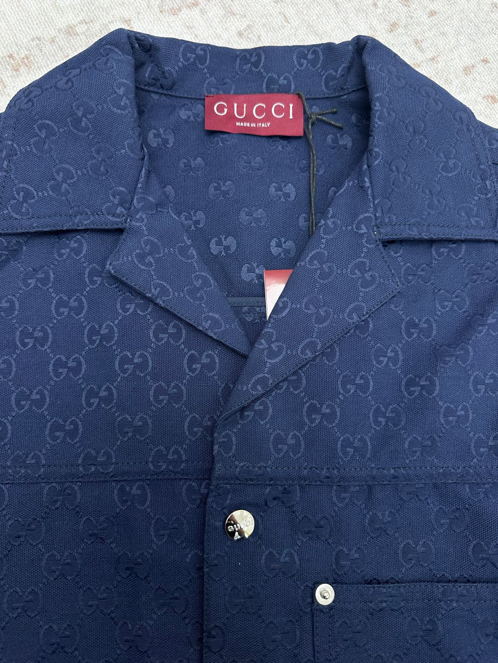 Dark navy Gucci-pattern short-sleeve button-up shirt neckline with logo tag
