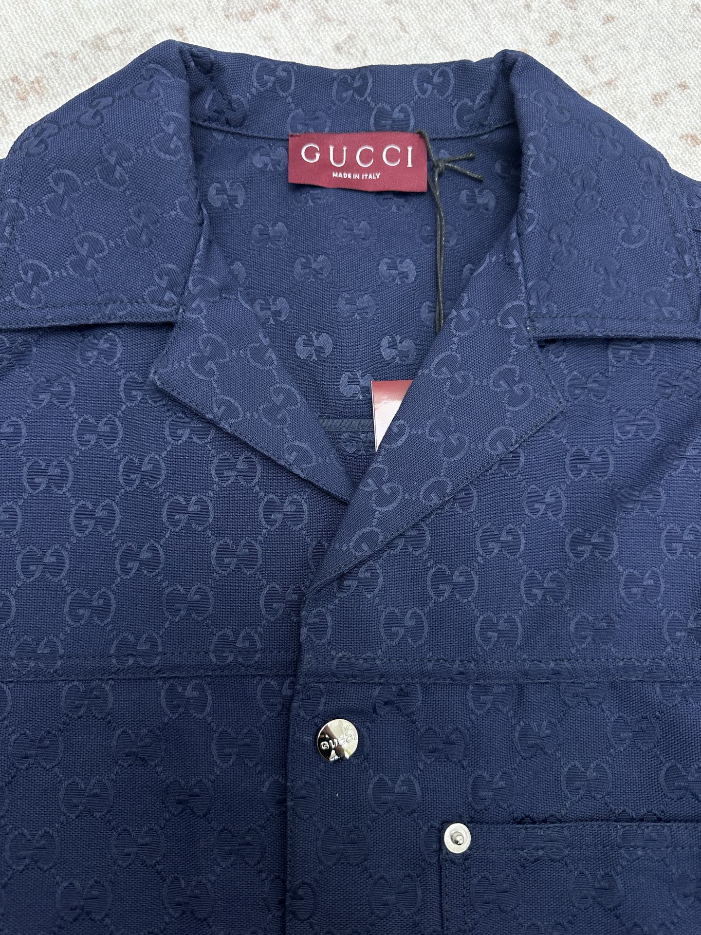 Dark navy Gucci-pattern short-sleeve button-up shirt neckline with logo tag