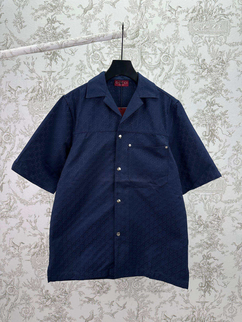 Dark navy short-sleeve button-up shirt with pointed collar and small front patch pockets