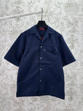 Dark navy short-sleeve button-up shirt with pointed collar and small front patch pockets