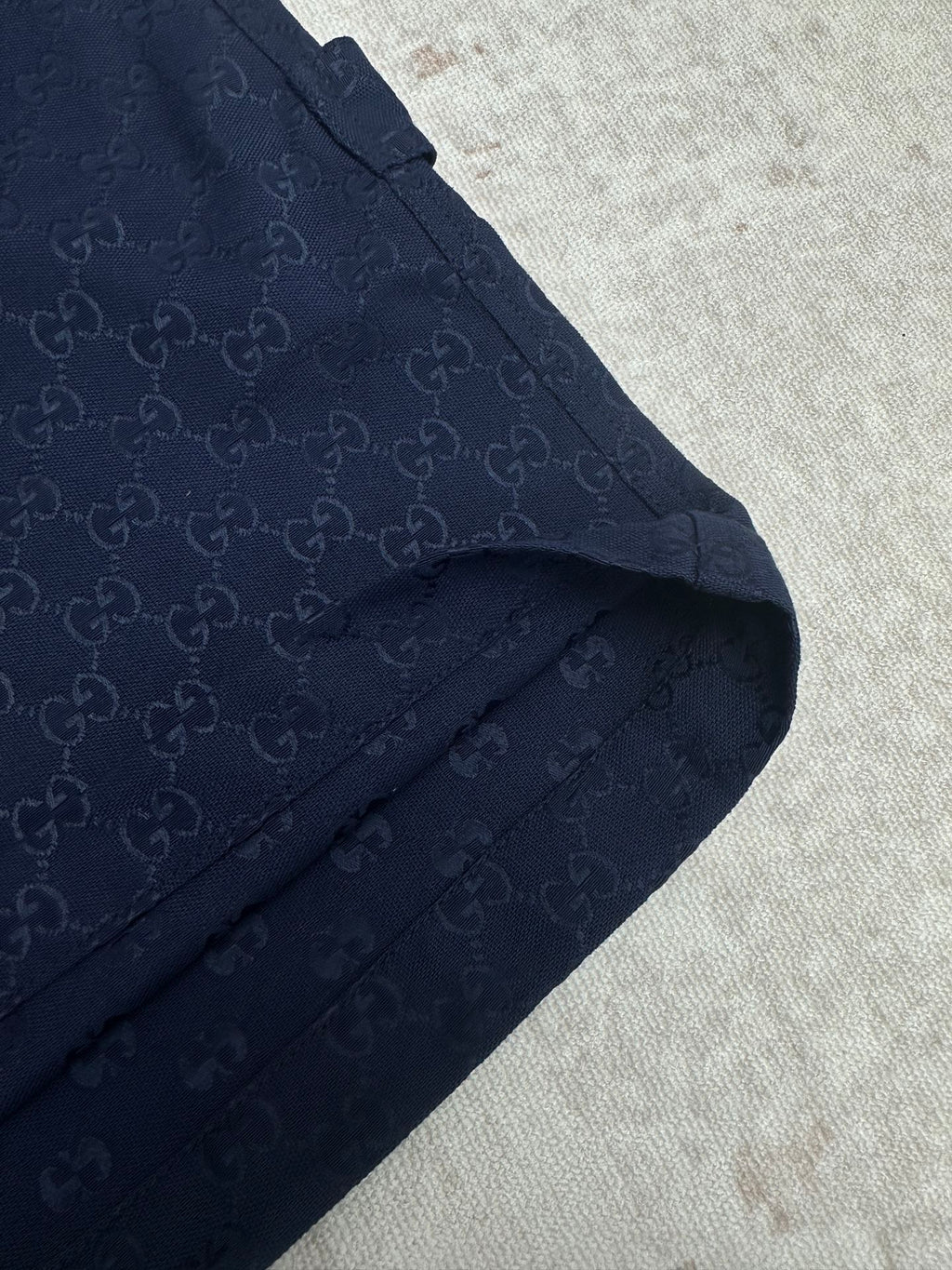 Gucci shorts in dark navy with monogram fabric, angled pocket, and seam