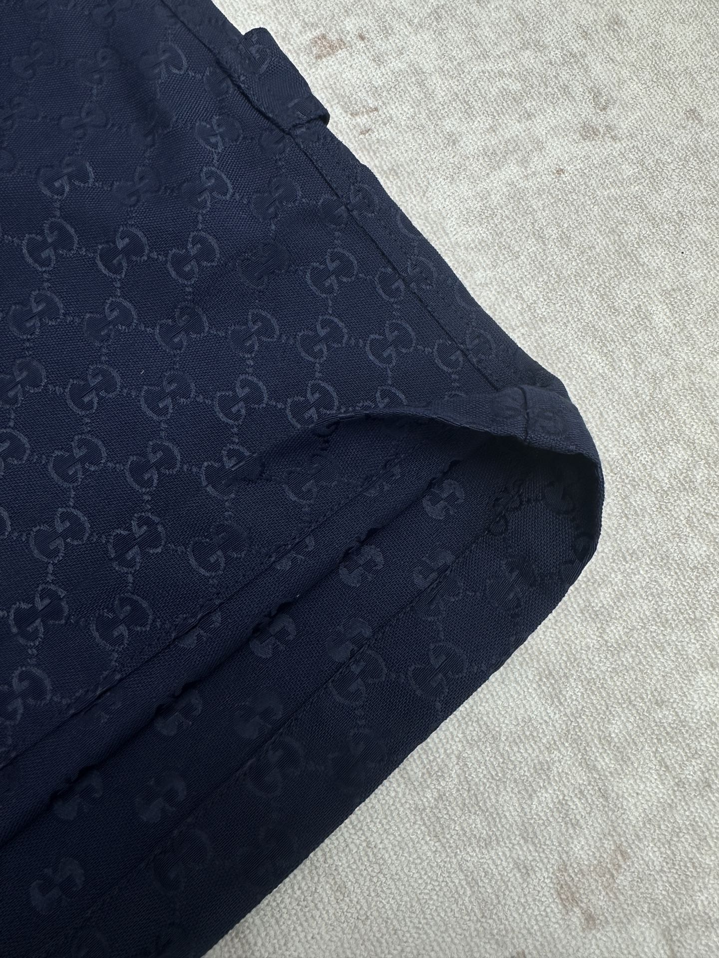 Gucci shorts in dark navy with monogram fabric, angled pocket, and seam