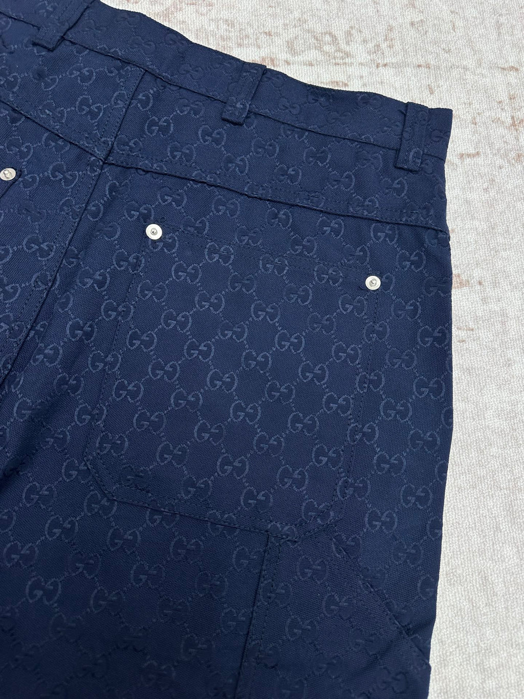 Gucci shorts in dark navy with monogram pattern, belt loops, and back flap