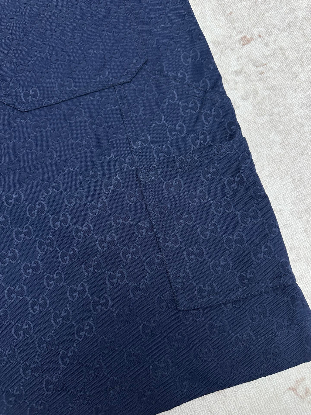 Gucci shorts in dark navy with monogram pattern, flap pocket, and button