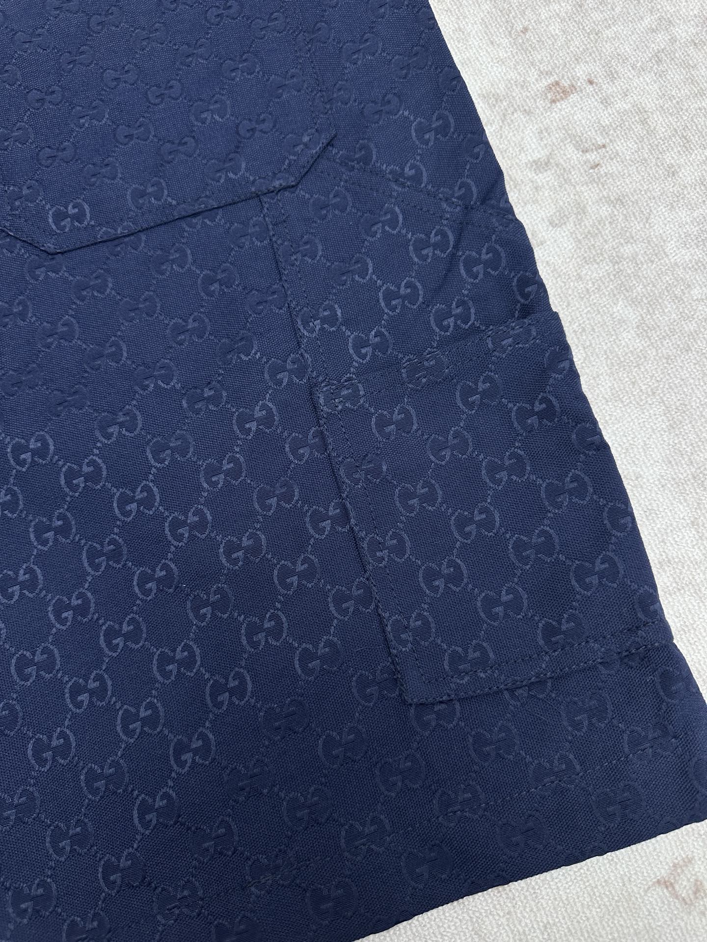 Gucci shorts in dark navy with monogram pattern, flap pocket, and button
