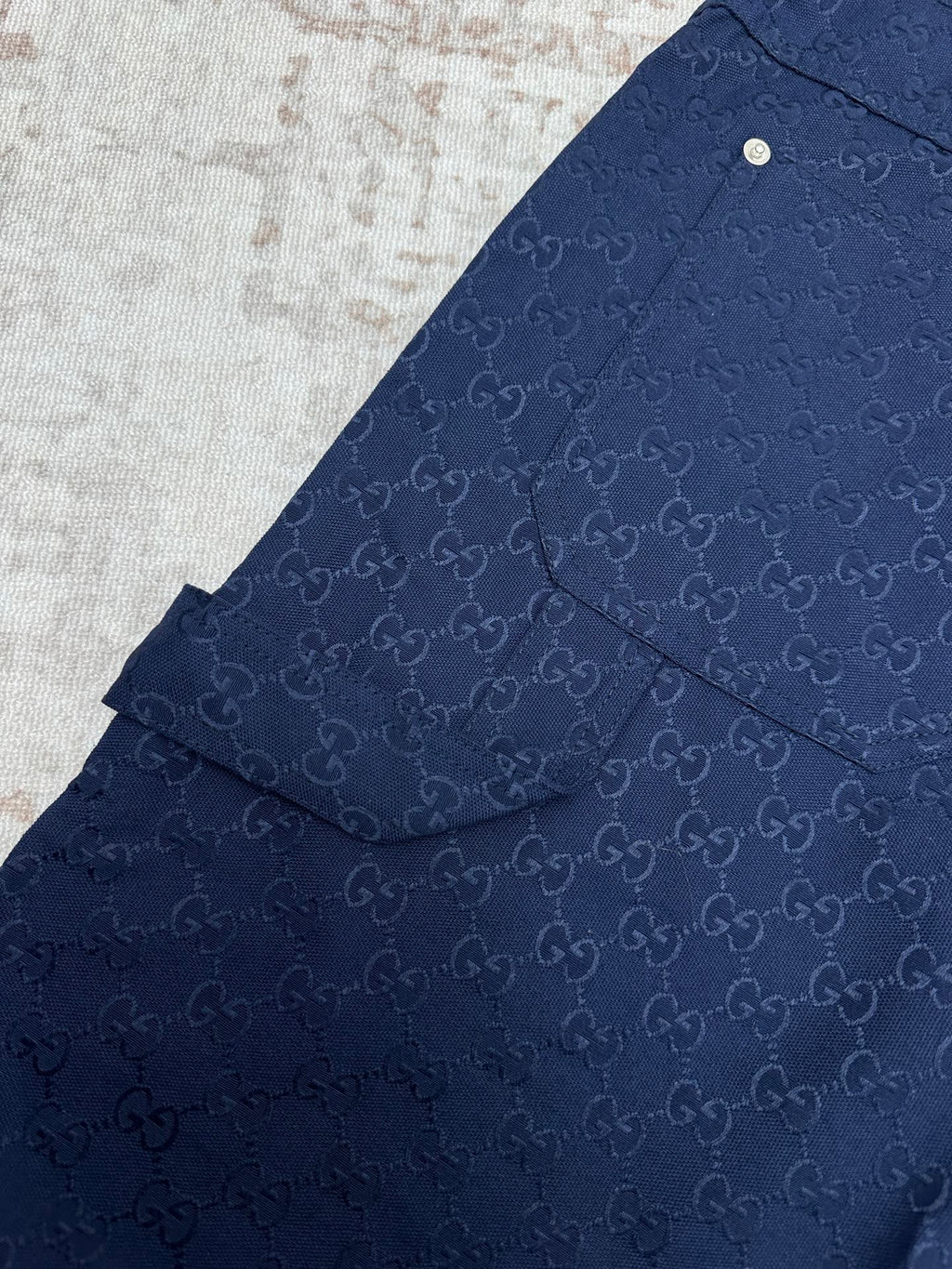 Gucci shorts in dark navy with monogram pattern, yoke seam, and side flap